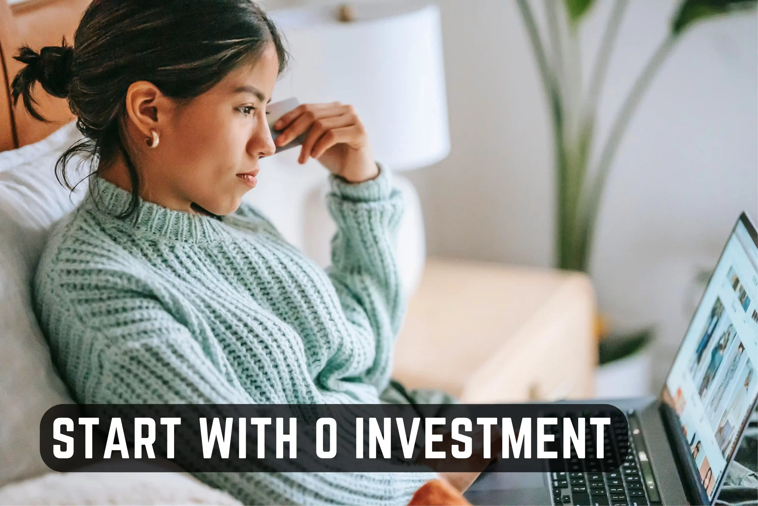 A determined woman sits comfortably on her couch, a laptop resting on her lap thinking about starting a business with no money